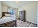 Cozy bedroom with wood floors, a bed with a wood frame, and a dresser with decorative hardware at 17232 N 29Th Ave, Phoenix, AZ 85053