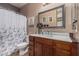 Cozy bathroom featuring a shower and floral curtain, with a gray framed mirror above the vanity at 1849 S Balboa Dr, Gilbert, AZ 85295