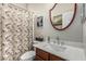 Bathroom features vanity with solid countertops, framed mirror, and decorative floral shower curtain at 1849 S Balboa Dr, Gilbert, AZ 85295