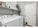 Laundry room features washer and dryer with overhead shelving and access to the exterior at 1849 S Balboa Dr, Gilbert, AZ 85295
