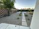 Landscaped backyard with gravel, stone pavers, a fire pit, and perimeter fencing with mature trees at 1930 W Missouri Ave, Phoenix, AZ 85015