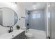 Well-lit bathroom features a combination tub and shower with modern fixtures and gray tiling at 1930 W Missouri Ave, Phoenix, AZ 85015