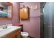 Cozy bathroom featuring a vanity sink, mirrored cabinet, toilet, and enclosed shower with black tile at 19648 N 8Th Pl, Phoenix, AZ 85024