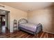Neutral-toned bedroom with a small, wrought iron bed frame and laminate wood flooring at 19648 N 8Th Pl, Phoenix, AZ 85024