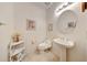 Powder room featuring a pedestal sink, a toilet, and decorative wall art at 19662 N Overton Ct, Surprise, AZ 85374