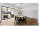 Dining room with contemporary table, wood-look tile flooring, and glass sliding doors to patio at 21120 E Superstition Dr, Queen Creek, AZ 85142