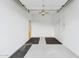 An empty two car garage, with grey and black sealed concrete floors and basic lighting at 21120 E Superstition Dr, Queen Creek, AZ 85142