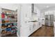 Open concept kitchen with stainless steel refrigerator, white cabinets, and walk-in pantry at 21120 E Superstition Dr, Queen Creek, AZ 85142