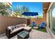 Inviting backyard featuring a comfortable seating area, a vibrant blue umbrella, and a charming fire pit at 23083 N 74Th Pl, Scottsdale, AZ 85255