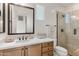 Elegant bathroom with a wood vanity, modern fixtures, and a glass-enclosed shower at 23083 N 74Th Pl, Scottsdale, AZ 85255