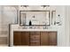 Bathroom featuring double vanity sinks, sleek countertops, and a glass-enclosed shower providing a spa-like experience at 23083 N 74Th Pl, Scottsdale, AZ 85255