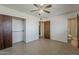 Bright bedroom with tan tiled floors, a ceiling fan and access to an ensuite bathroom and closet at 2432 W Echo Ln, Phoenix, AZ 85021