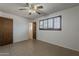 Sunlit bedroom featuring tan tiled floors, a ceiling fan, and window shutters for adjustable light control at 2432 W Echo Ln, Phoenix, AZ 85021