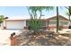 Beautiful front exterior featuring desert landscaping, charming brick accents, and a two-car garage at 2432 W Echo Ln, Phoenix, AZ 85021