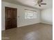 Bright, airy living room with neutral tile flooring, a ceiling fan, and a large window at 2432 W Echo Ln, Phoenix, AZ 85021