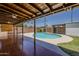 Expansive covered patio with ceiling fans and a view of the backyard pool and grassy area at 2432 W Echo Ln, Phoenix, AZ 85021