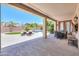 A serene backyard featuring a covered patio, outdoor seating, a swimming pool, and lush greenery at 2514 E Grand Canyon Dr, Chandler, AZ 85249