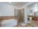 Bright bathroom with glass enclosed shower, large soaking tub, and mirrored closet doors at 2514 E Grand Canyon Dr, Chandler, AZ 85249