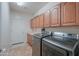 Functional laundry room with modern washer and dryer, built-in cabinets, and tile flooring at 2514 E Grand Canyon Dr, Chandler, AZ 85249