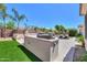 An outdoor kitchen with grill, stone counter, artificial turf, and backyard seating area for entertaining at 2514 E Grand Canyon Dr, Chandler, AZ 85249