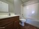Bathroom with a wood vanity, a white toilet, and a tub with shower, combining functionality with classic style at 25748 W Siesta Way, Buckeye, AZ 85326