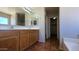 Bright bathroom featuring a double sink vanity, tiled floor, large mirror, and en suite entrance at 25748 W Siesta Way, Buckeye, AZ 85326