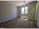 A bright bedroom featuring neutral walls and plush carpeting illuminated by natural light from a window at 25748 W Siesta Way, Buckeye, AZ 85326