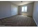 Bright bedroom with a window and closet doors, a calm space with ample natural light and storage at 25748 W Siesta Way, Buckeye, AZ 85326