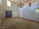 Spacious living room featuring high ceilings, a chandelier, and staircase at 25748 W Siesta Way, Buckeye, AZ 85326