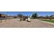 Community playground with slides and play structures near tree-lined streets and lush green grass at 25748 W Siesta Way, Buckeye, AZ 85326