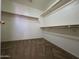 Spacious walk-in closet with built-in shelving and carpeted floor, providing ample storage space at 25748 W Siesta Way, Buckeye, AZ 85326