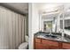 Bathroom with a granite sink, wood cabinets, and a shower/tub combo at 2625 E Indian School Rd # 206, Phoenix, AZ 85016
