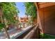 View from balcony of complex with mature trees and brick lined walkways under a sunny sky at 2625 E Indian School Rd # 206, Phoenix, AZ 85016