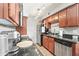Galley kitchen featuring dark countertops, stainless steel appliances, and warm wood cabinets at 2625 E Indian School Rd # 206, Phoenix, AZ 85016
