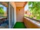 Private balcony with green turf, overlooking lush greenery and part of the community at 2625 E Indian School Rd # 206, Phoenix, AZ 85016
