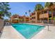 Community pool with clear blue water surrounded by lush landscaping and a relaxing cabana at 2625 E Indian School Rd # 206, Phoenix, AZ 85016