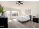 Inviting main bedroom features plush carpet, a ceiling fan, and a large window overlooking the backyard at 2716 N Kristen --, Mesa, AZ 85213