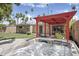 Relaxing backyard featuring a spa, red pergola, and lush landscaping with palm trees at 3018 E Mulberry Dr, Phoenix, AZ 85016