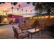 Beautiful backyard with comfortable seating, string lights, pergola, and palm trees at dusk at 3018 E Mulberry Dr, Phoenix, AZ 85016