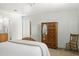 View of the bedroom, showcasing an oval mirror on a wooden dresser and decorative wooden chair at 3018 E Mulberry Dr, Phoenix, AZ 85016