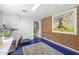 Bonus room with a brick accent wall, blue floors, and exercise equipment at 3018 E Mulberry Dr, Phoenix, AZ 85016
