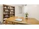 Home office features a large desk, built-in bookshelf, and natural light from the window at 3018 E Mulberry Dr, Phoenix, AZ 85016