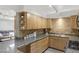 Functional kitchen featuring tiled backsplash, granite countertops, and wood cabinets at 3018 E Mulberry Dr, Phoenix, AZ 85016