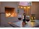 Close-up of an outdoor fireplace setting with wine, glasses, and a rose on a table at 3018 E Mulberry Dr, Phoenix, AZ 85016