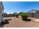 Spacious backyard featuring gravel landscaping, greenery, block wall and sandbox area at 30938 W Mitchell Dr, Buckeye, AZ 85396