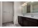 Bathroom featuring double sink vanity, dark wood cabinets, and a large mirror at 30938 W Mitchell Dr, Buckeye, AZ 85396