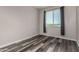 Bright bedroom with gray walls, wood-look floors, and large window, providing natural light and comfortable living at 30938 W Mitchell Dr, Buckeye, AZ 85396