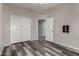 Spacious bedroom with gray walls, wood-look floors, and closet providing functional space and style at 30938 W Mitchell Dr, Buckeye, AZ 85396