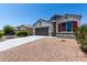 Attractive single-story house with desert landscaping, two-car garage and a blue sky at 30938 W Mitchell Dr, Buckeye, AZ 85396
