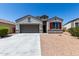 Charming single-story home features a two-car garage and desert landscaping at 30938 W Mitchell Dr, Buckeye, AZ 85396